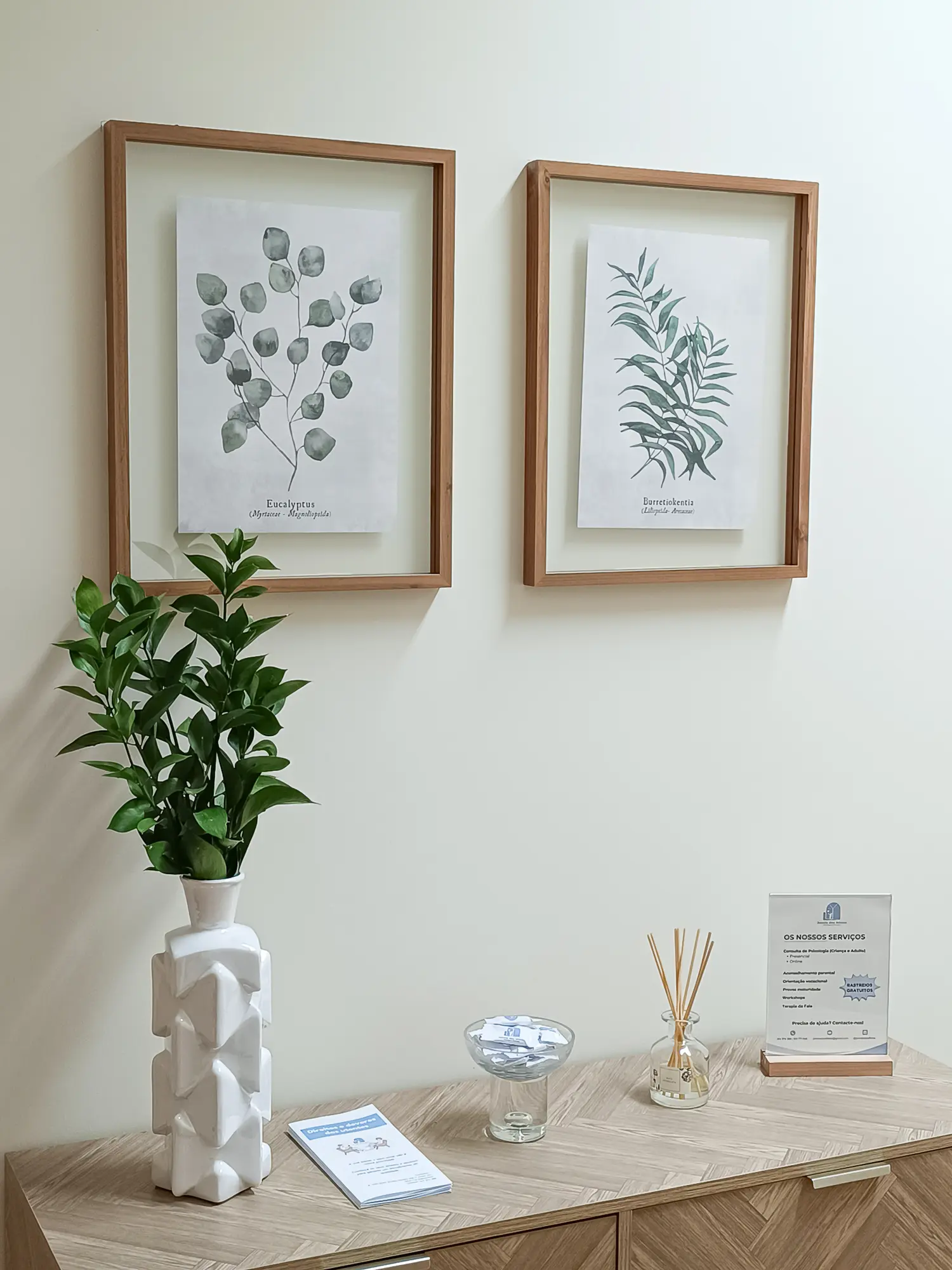 Pormenor da consola, planta e quadros na receção da Janela dos Afetos